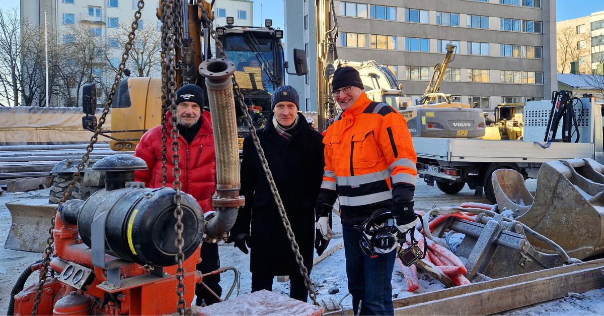 Tre personer från Stiftelsen Eschnerska Frilasarettet, C.G. Sundells stiftelse och Karavanen till Ukraina står vid ett reservkraftverk på byggarbetsplatsen för Kaskia välfärdskvarter i Åbo